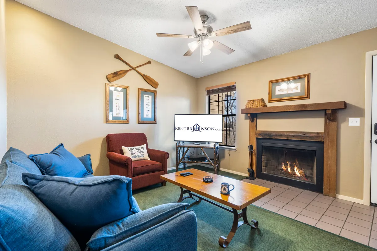 The image showcases a warm and inviting living room with a cozy fireplace as the focal point, a plush sofa arranged for conversation or relaxation, a stylish coffee table, and tasteful wall decor. The scene suggests a perfect spot for families or couples to unwind, whether sipping hot cocoa by the fire, enjoying a game night, or watching a movie together.