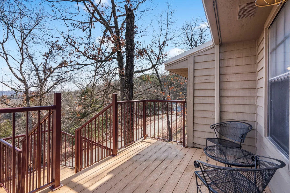 A serene private balcony with comfortable seating, surrounded by trees and a tranquil forest view. The balcony’s railing and arrangement suggest a peaceful space to enjoy coffee or unwind.